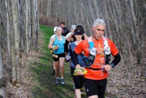 Group of runners on wooded trail