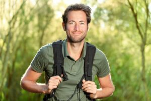 young man smiles wearing backpack
