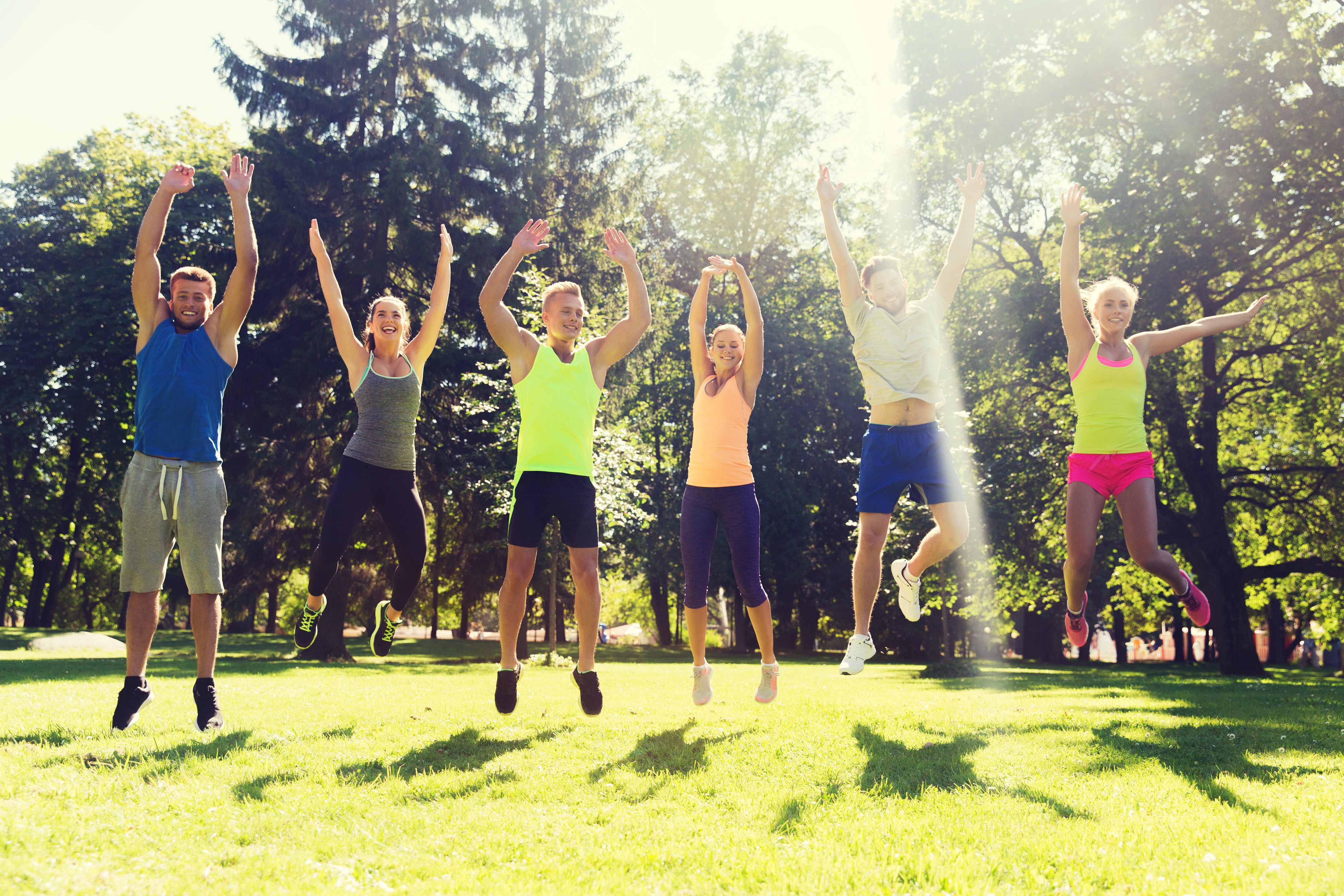 group of happy friends jumping high outdoors