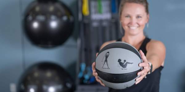 smiling woman holds Smart Medicine Ball