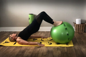 Woman does Glute Bridge with feet on Smart Stability Ball